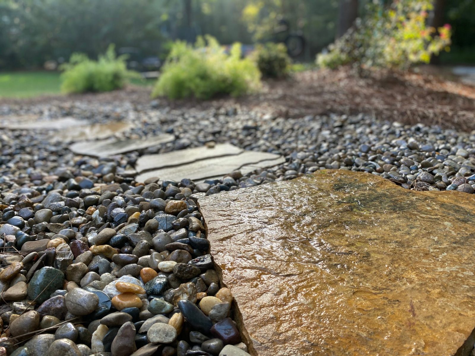 Dry creek bed of river rock carrying runoff away from a lawn in Columbia County, Georgia