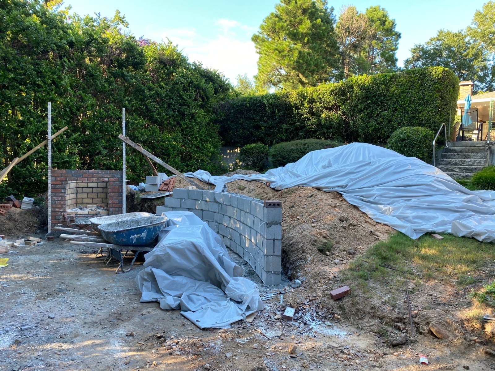 Block retaining wall under construction with materials staged on site