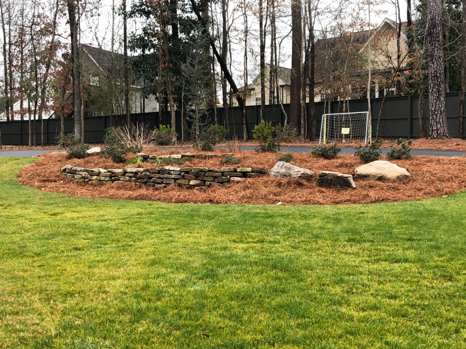 Mulched island bed with boulders set in a maintained residential lawn